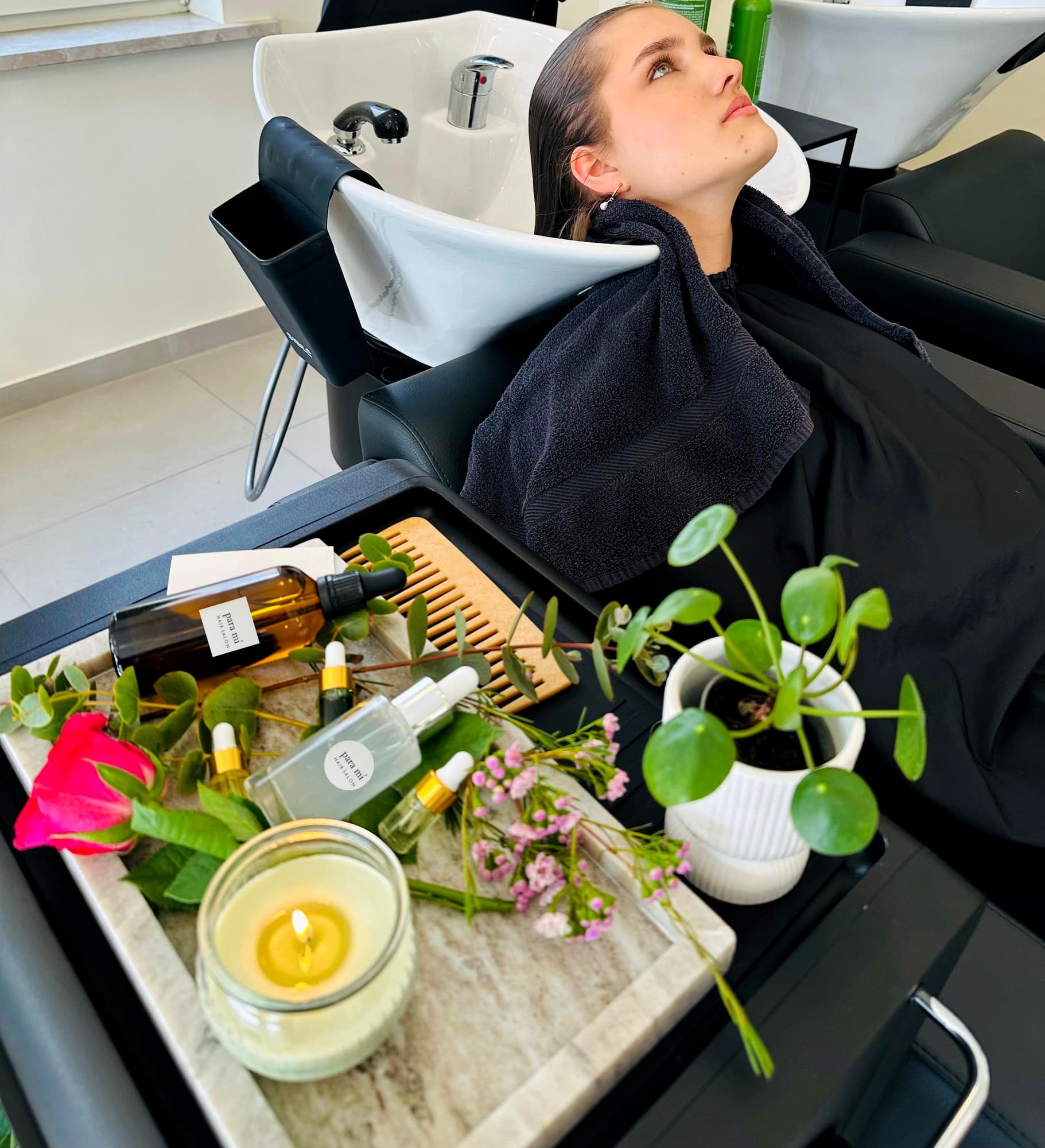 Natural Oil Therapy am Waschplatz: Öle, Kerze und frische Blüten auf dem Tablett